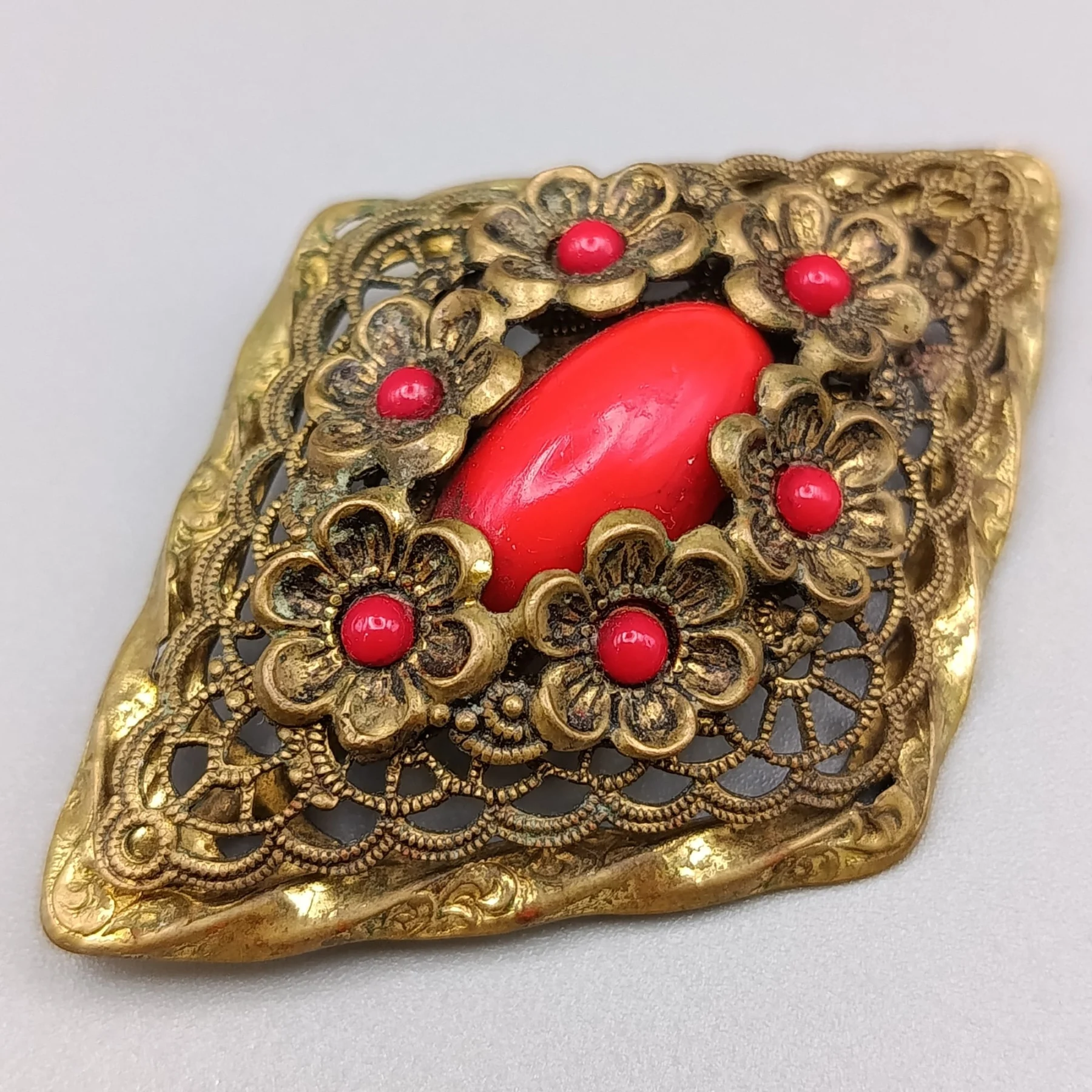 Brosche mit rotem Schmuckstein und filigraner Fassung